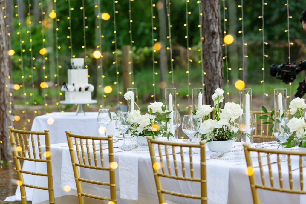 White and Green reception table with gold chairs and magical twinkle lights at Forest Wedding Venue in Florida