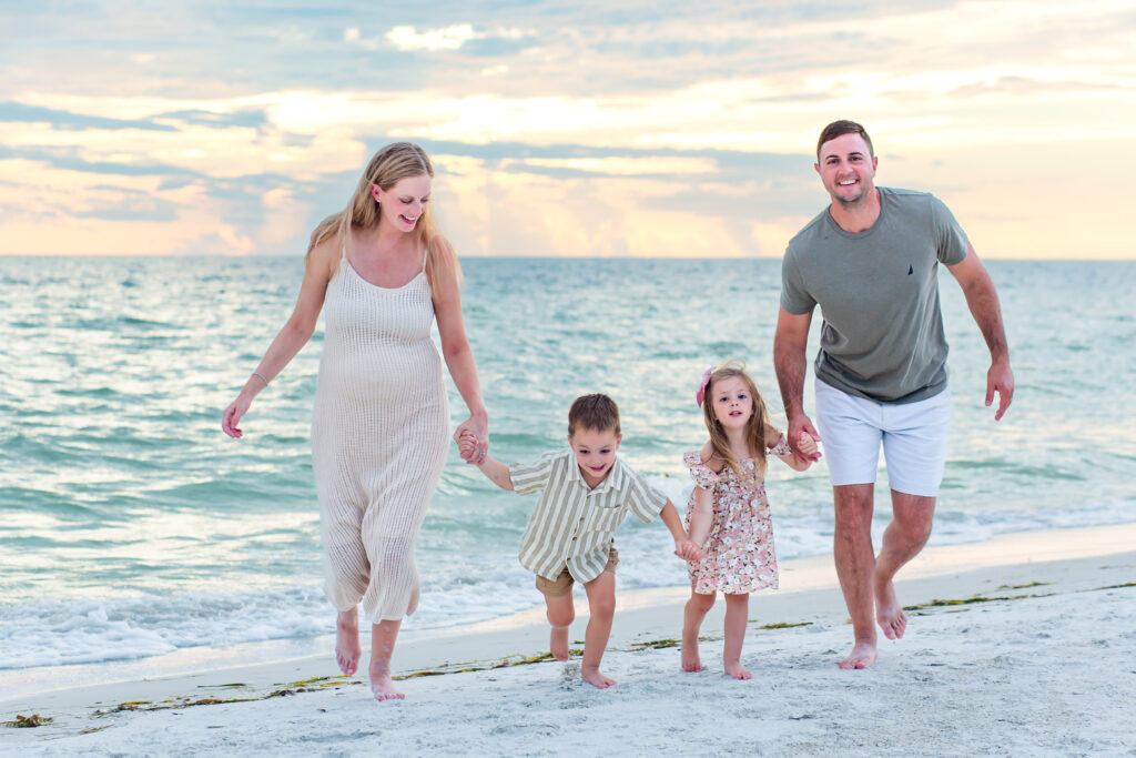 Family running on the beach at sunset for their Anna Maria Island photo session