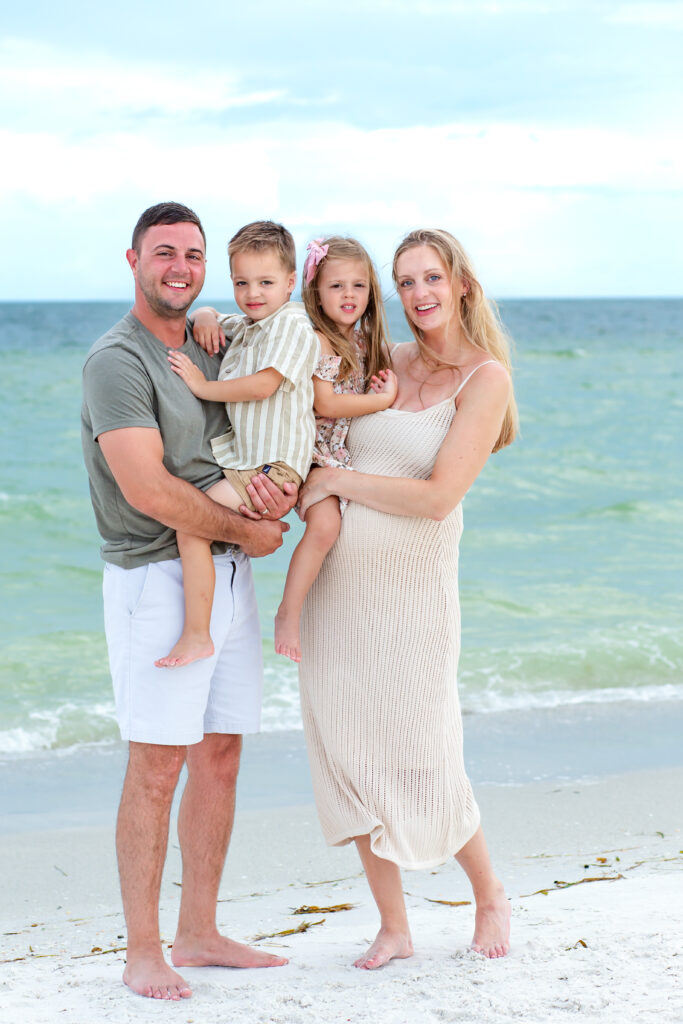 Family poses on the beach at sunset for their Anna Maria Island photo session