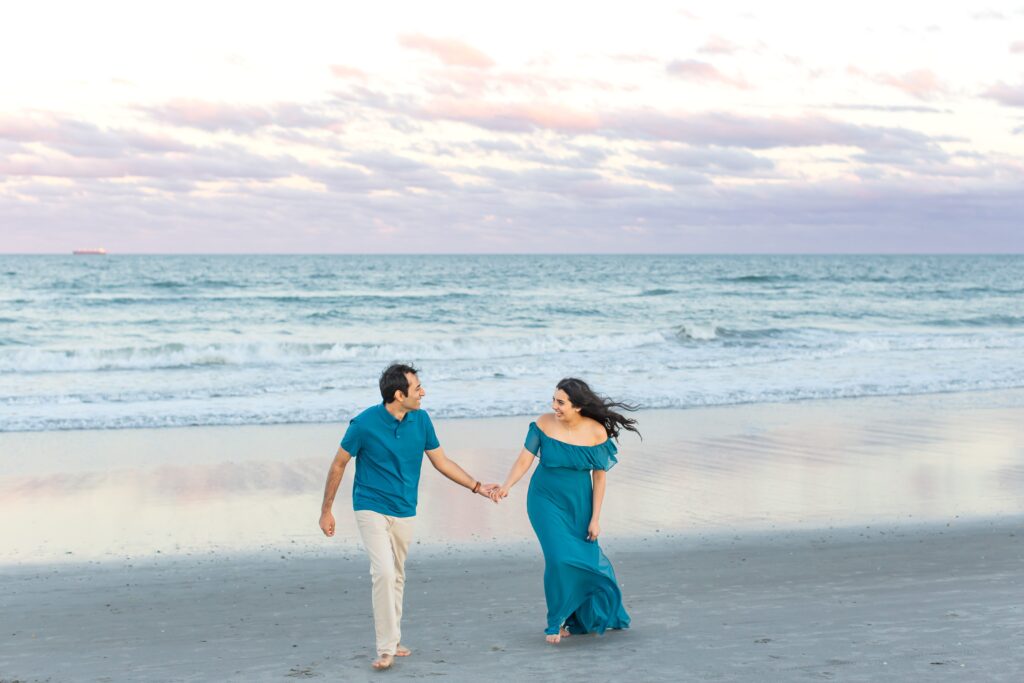 Couple walking on the beach at sunset on the beach for their engagement photos in Cocoa Beach Florida