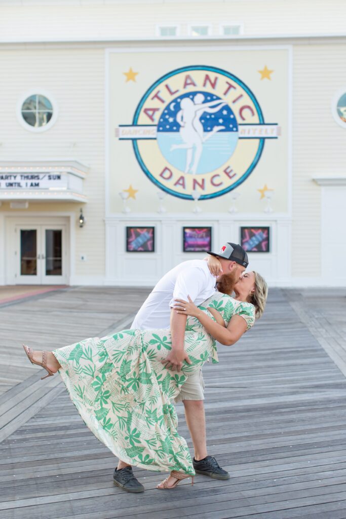Guy dips Girl as they dance in front of the Dance Hall at the Boardwalk for their Disney Engagement Photos