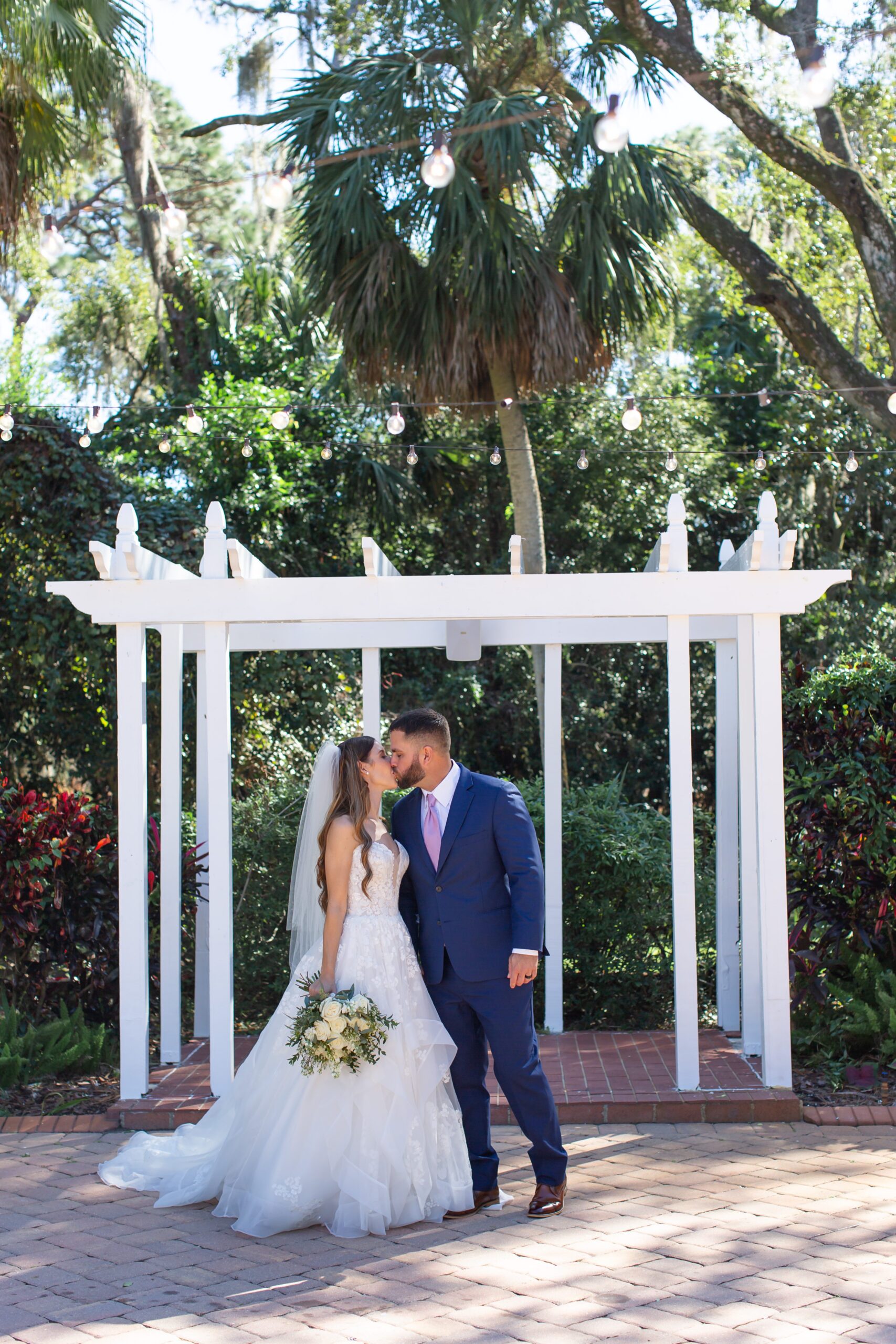 Couple kisses under arbor canopy at their micro wedding at the Garden Villa in Winter Park, Florida