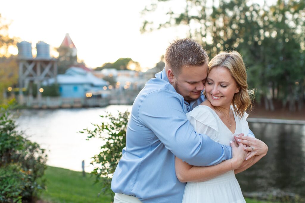 Couple snuggles in front of Riverside scene at sunset for their Disney Engagement Photos at Port Orleans Resort