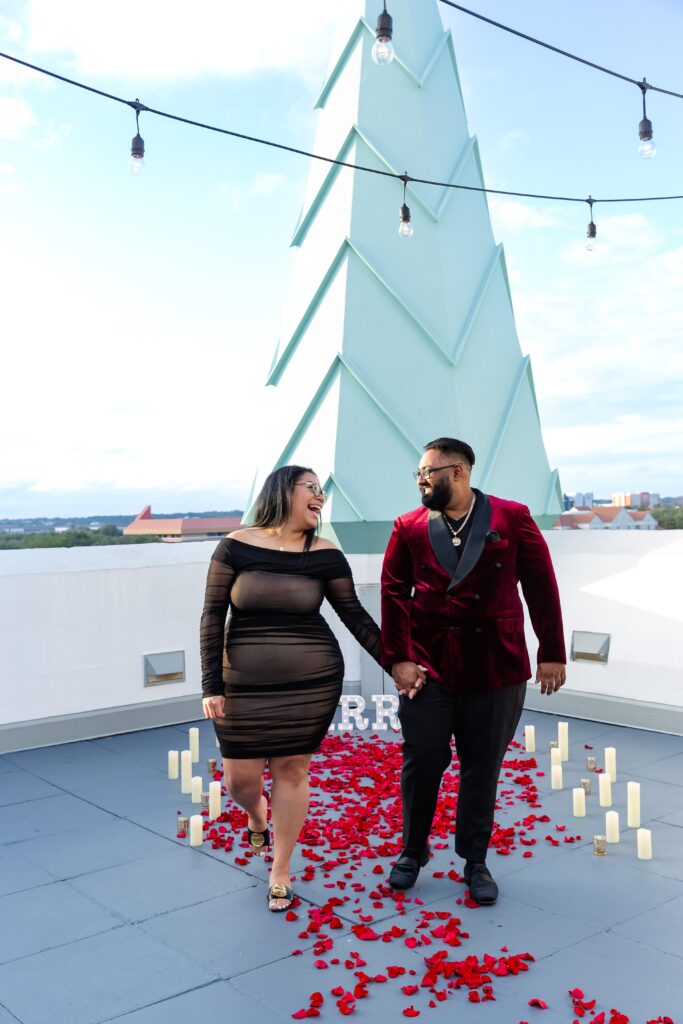 Couple laughing together and holding hands after their proposal on the rooftop of Castle Hotel Orlando