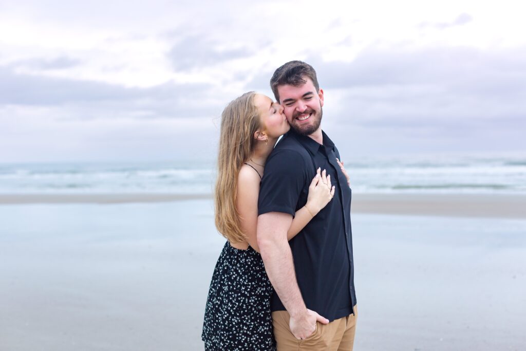 Girl kisses guy on beach after their proposal for their New Smyrna Beach Photos