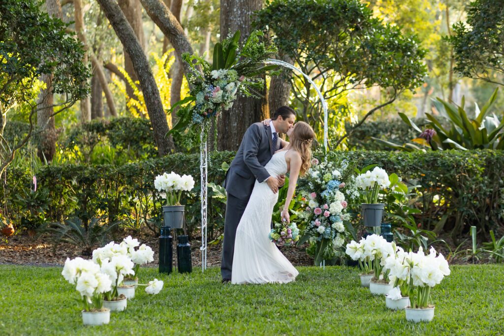 Groom dips Bride after their wedding ceremony at their back yard wedding in Orlando, Florida