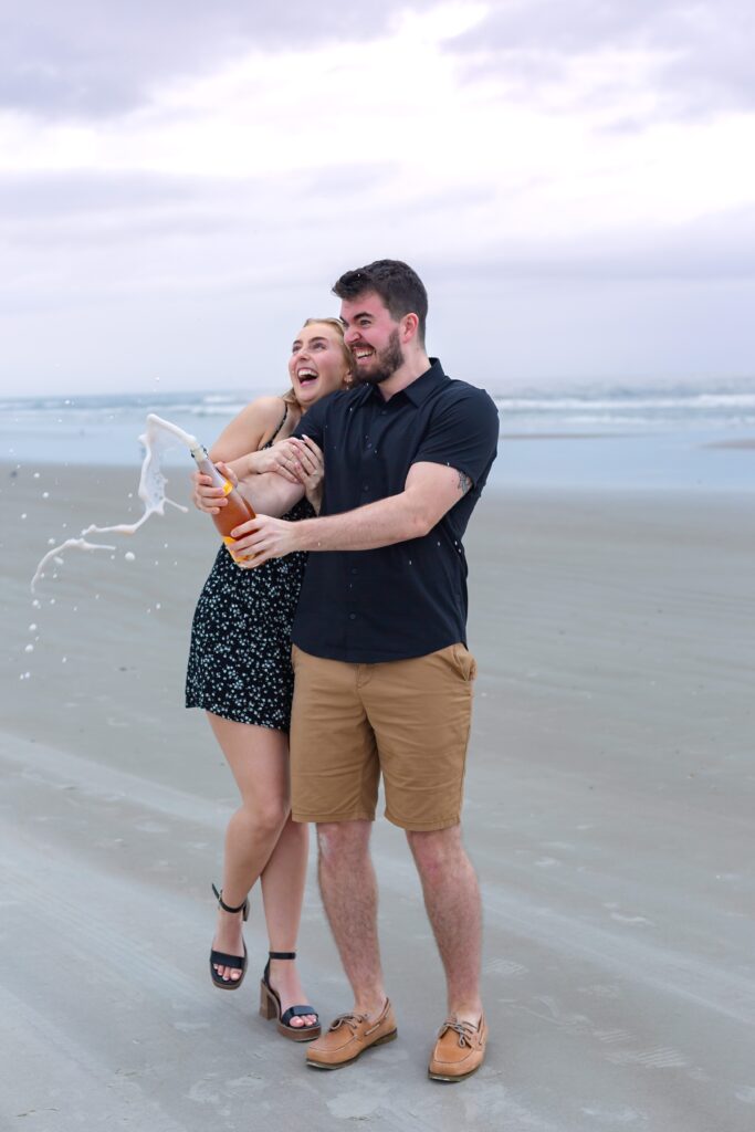 Couple pops champagne and laughs after proposal at with New Smyrna Beach Photos