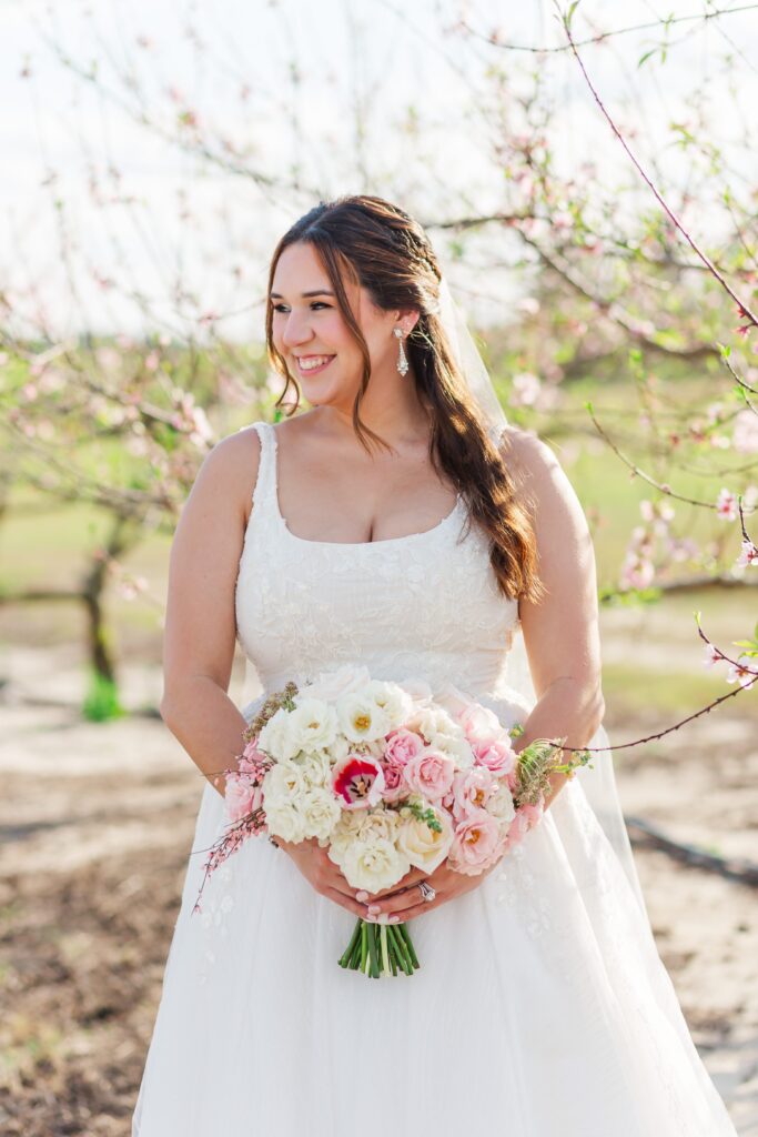 Bride smiling in Peach Orchard after her wedding at Acres of Grace Wedding Venue in Central Florida