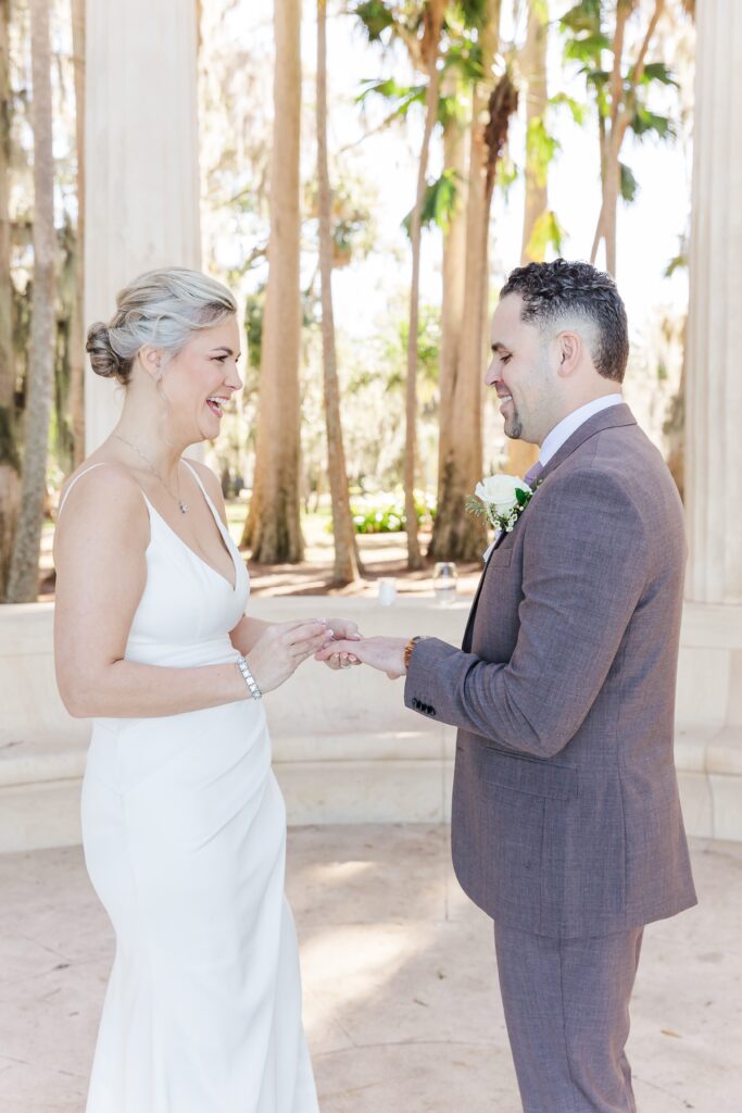 Bride and Groom exchange rings at the exedra columns for their wedding ceremony at Kraft Azalea Garden Wedding in Orlando, Florida
