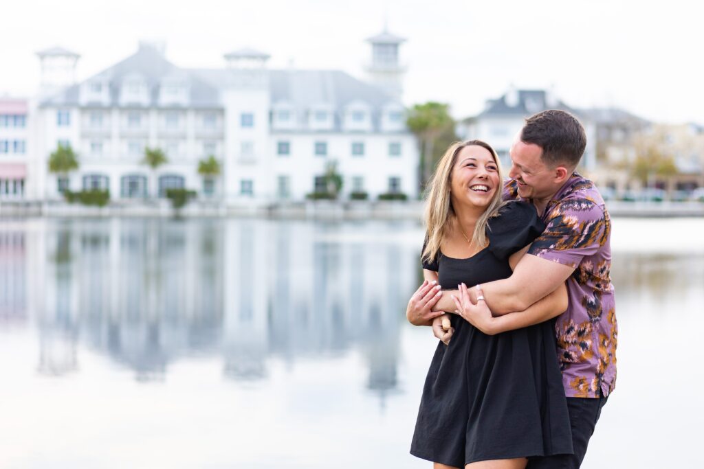 Guy hugs girl for their engagement photos in front of the Bohemian Hotel in Celebration, Florida