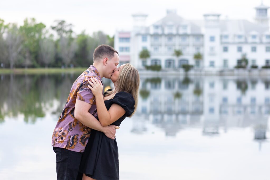 Couple kisses for their engagement photos in front of the Bohemian Hotel in Celebration, Florida