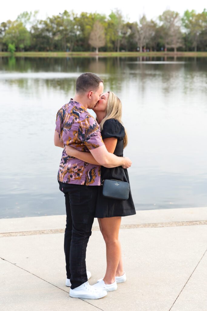 Couple kisses after Guy proposes to girl in front of the water on Front Street in Celebration, Florida