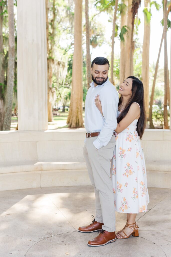 Couple smiles at each other for their engagement photos at Kraft Azalea Garden in Winter Park, FL