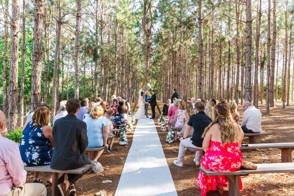Forest wedding ceremony under pine trees at The Pinery Orlando Wedding and Events in Howey in the Hills, FL