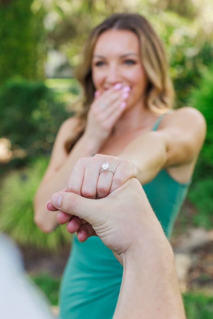 Girl holds out ring in shock after their proposal at Leu Gardens Orlando