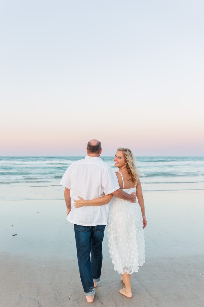 Couple walks on the beach for their anniversary photos with their New Smyrna Beach Photographer