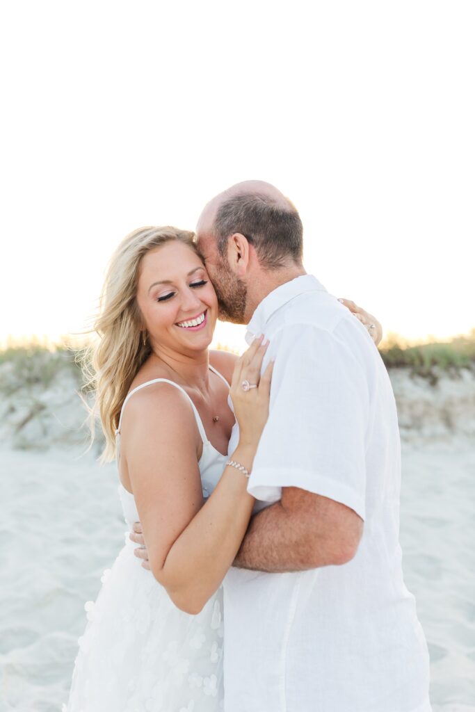 Couple snuggles in the sand dunes for their anniversary photos with their New Smyrna Beach Photographer