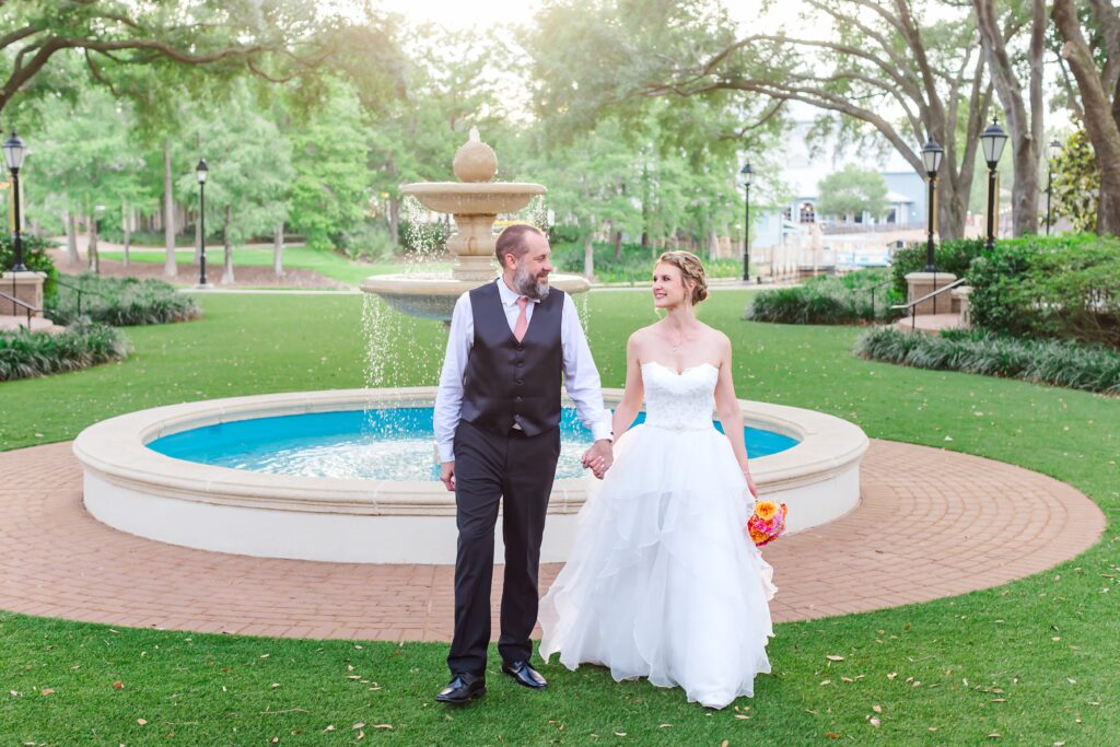 Bride and Groom walk in front of fountain after their Disney Elopement at Disney's Port Orleans Riverside Resort