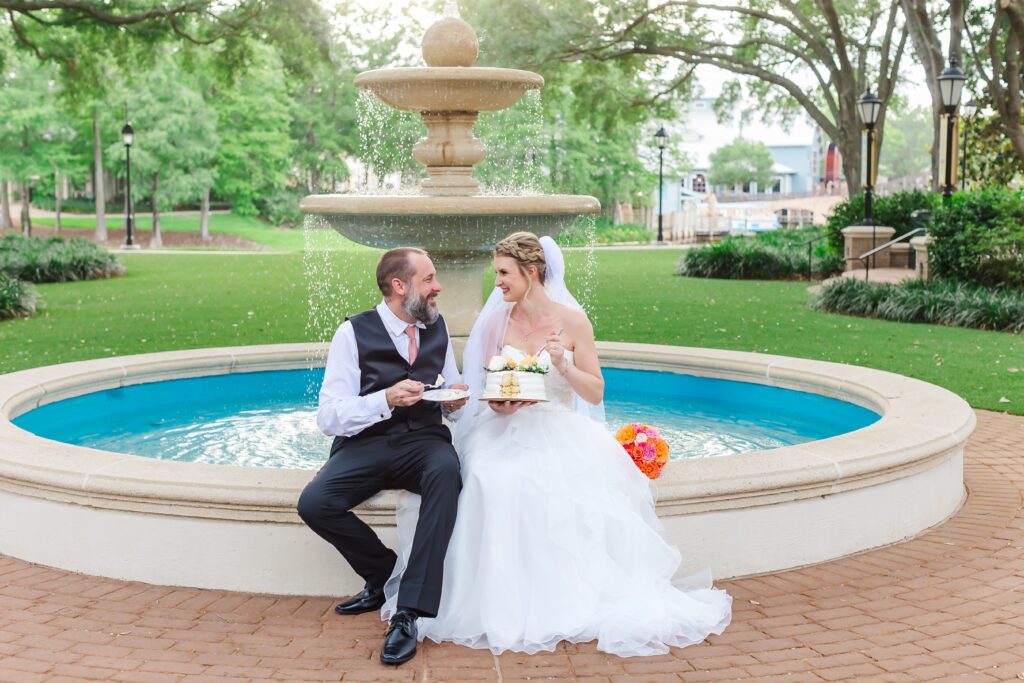 Bride and Groom have cake in front of fountain after their Disney Elopement at Disney's Port Orleans Riverside Resort