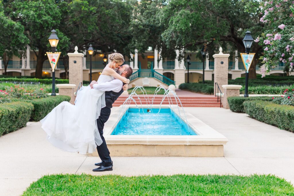 Groom picks up Bride in front of fountain after their Disney Elopement at Disney's Port Orleans Riverside Resort