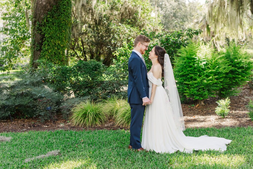 Bride and Groom smiling at each other during their first look at their Leu Gardens Wedding in Orlando, Florida