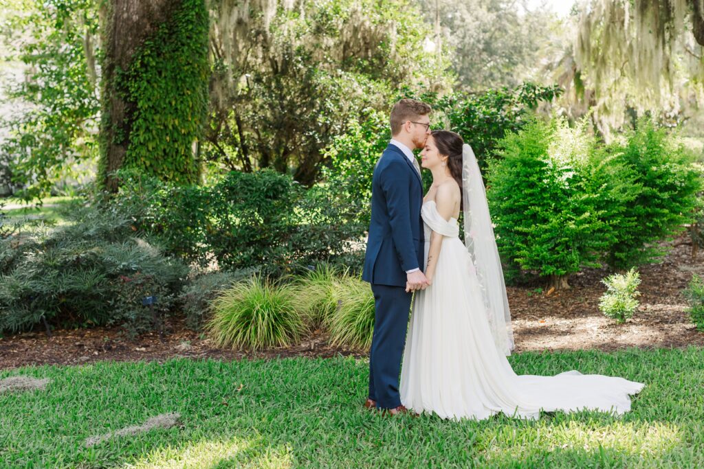 Groom kisses Bride's forehead during their first look at their Leu Gardens Wedding in Orlando, Florida