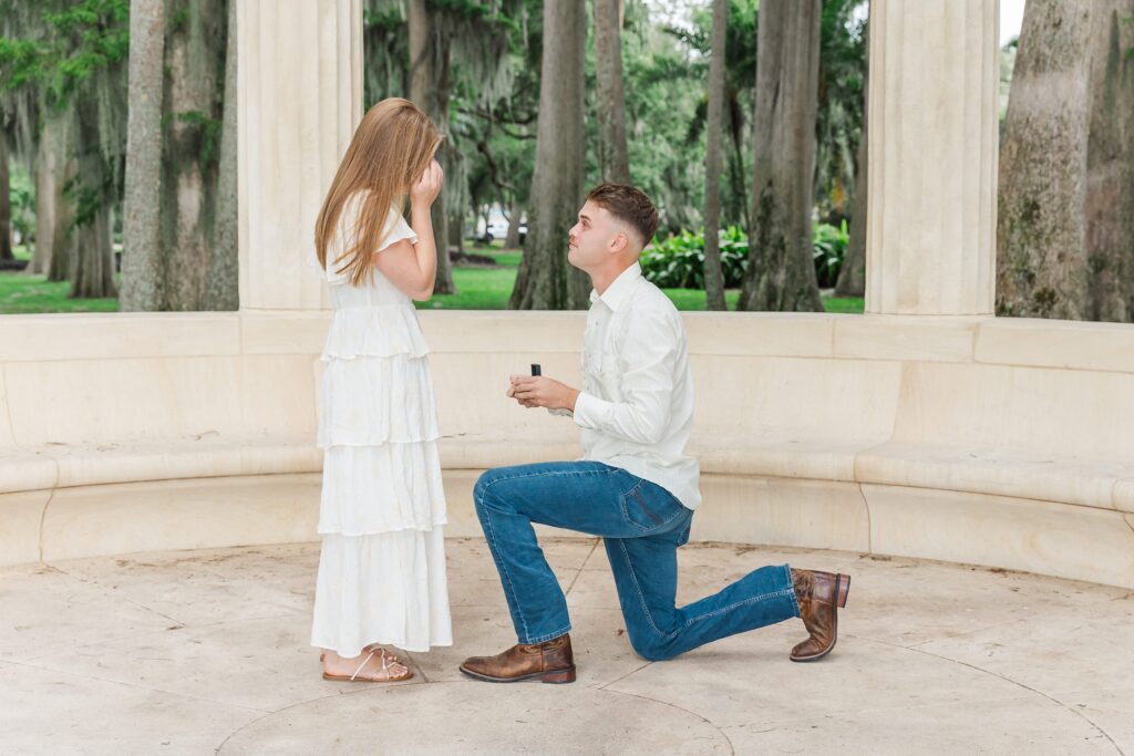 Guy proposes to girl in front of the columns at Kraft Azalea Garden in Orlando, Florida