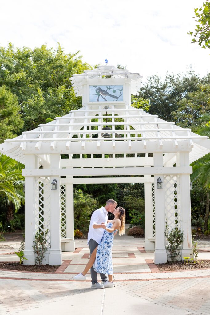Guy dips and kisses girl for their engagement photos in the idea garden at Leu Botanical Garden in Orlando, Florida