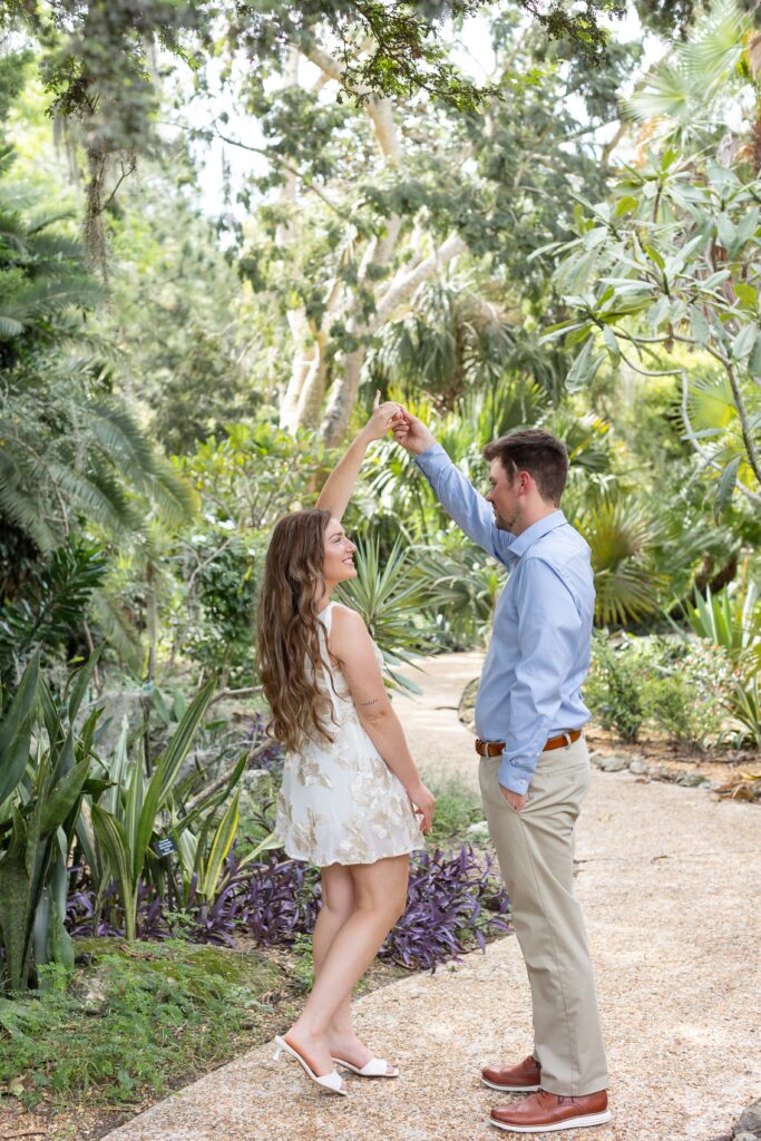 Guy twirls girl after their proposal at Leu Botanical Garden in Orlando, FL