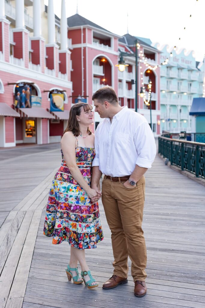 Couple holds hands and looks at each other for their Disney Engagement Photos at The Boardwalk