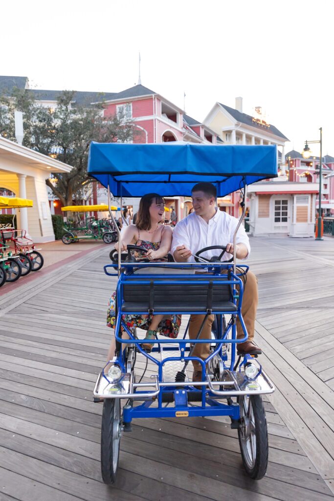 Couple rents surray bike and rides it for their Disney Engagement Photos at The Boardwalk