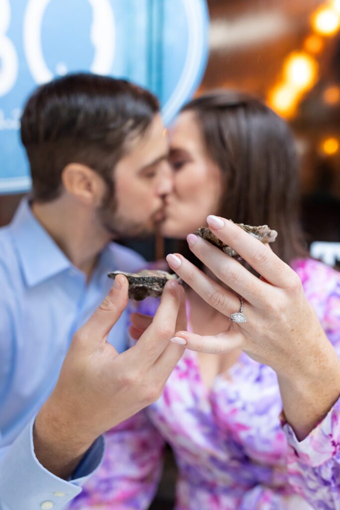 Couple kisses with oyster toast for their engagement photos at Atlantic Beer and Oyster on Park Ave in Winter Park, Florida