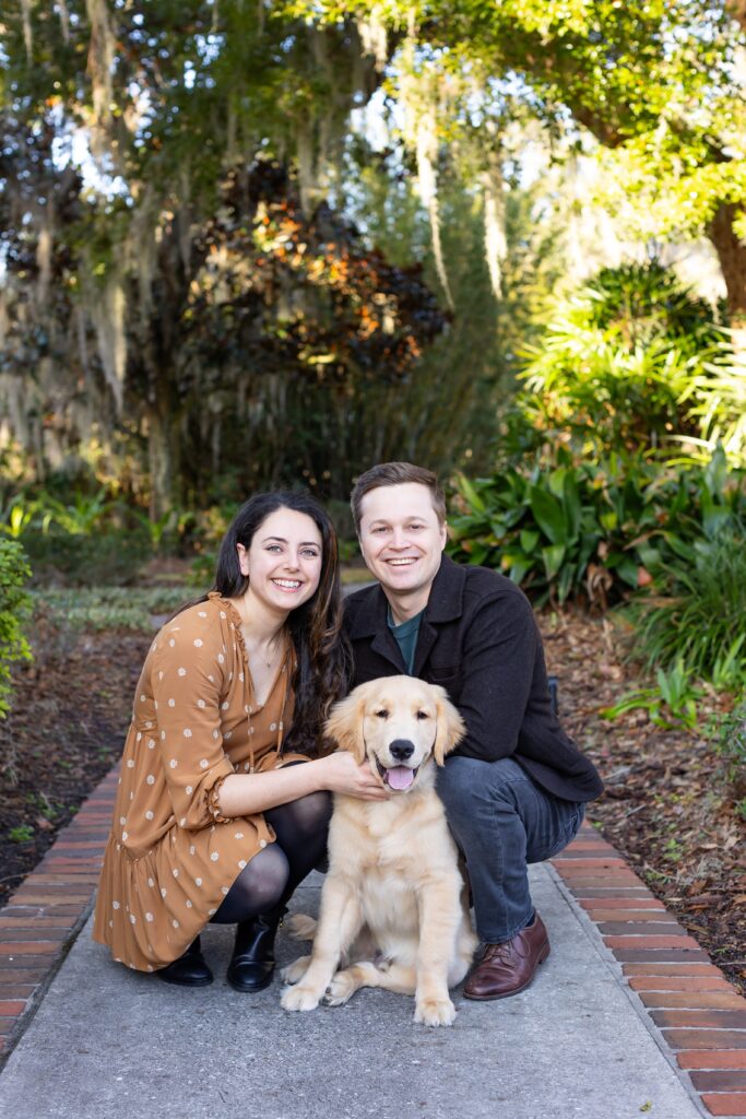 Couple poses with their dog for their engagement photos at Cypress Grove Park in Orlando, Florida