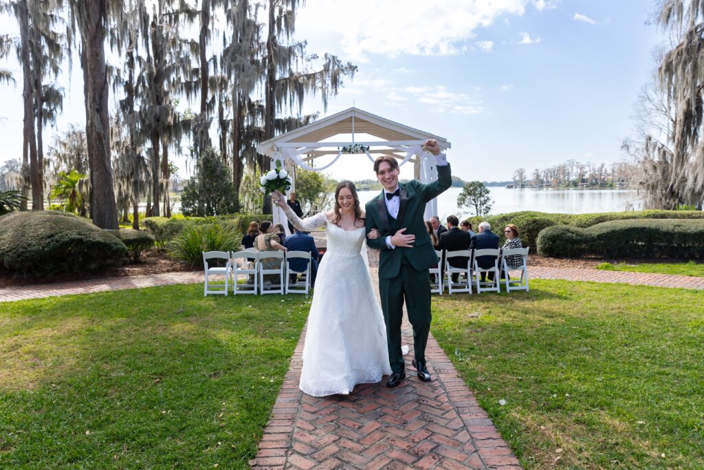 Bride and Groom walk down the aisle after their micro wedding at Cypress Grove Estate House in Orlando, Florida