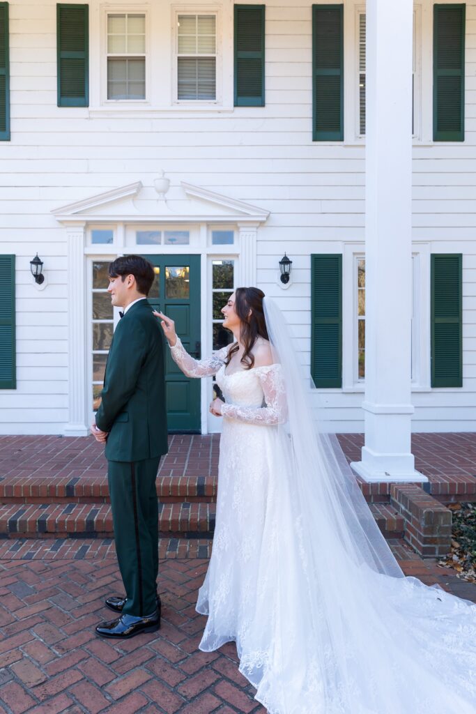 Bride taps Groom on shoulder for their first look before their micro wedding at Cypress Grove Estate House in Orlando, Florida