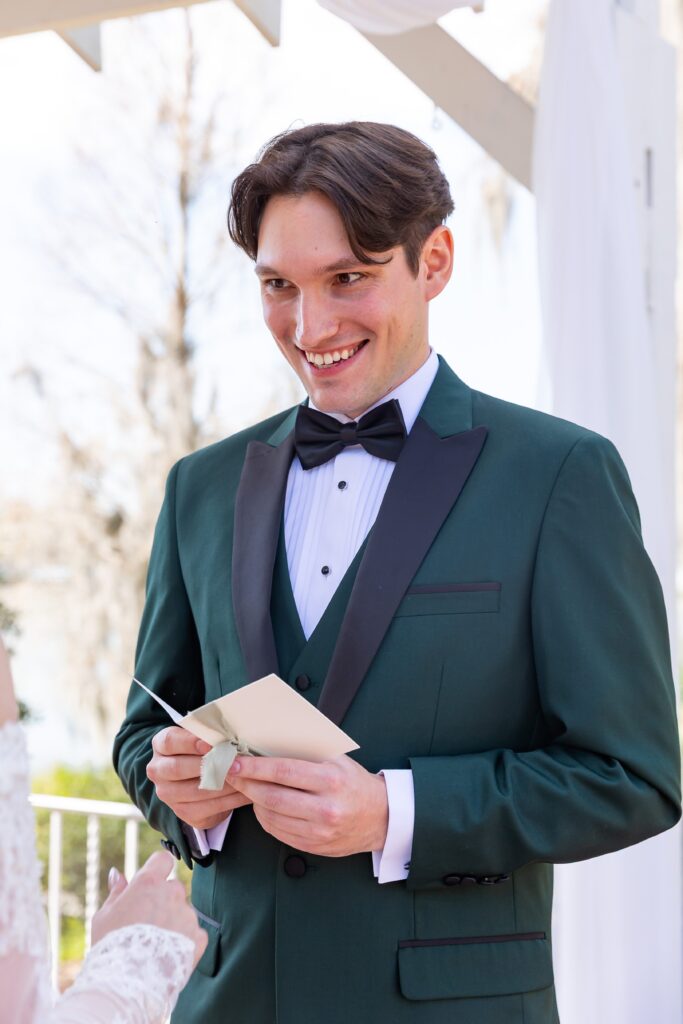 Groom smiles as he says his vows at his micro wedding at Cypress Grove Estate House in Orlando, Florida