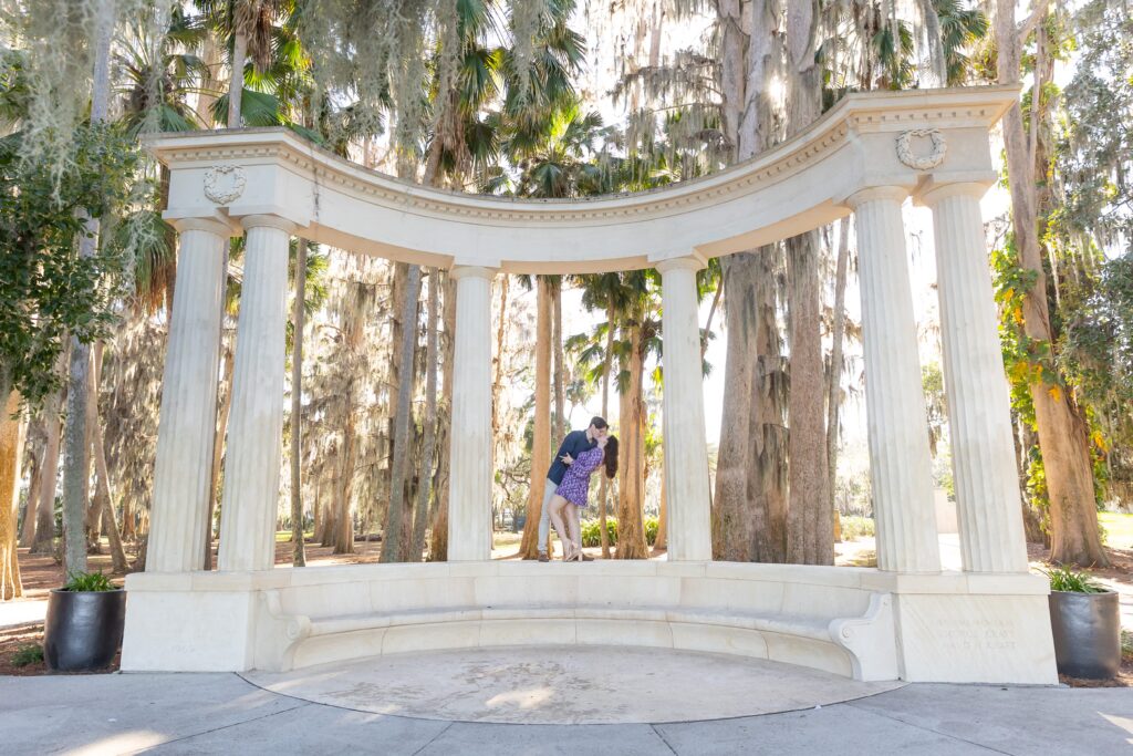 Guy dips girl and kisses her on top of columns for their engagement photos at Kraft Azalea in Orlando, Florida