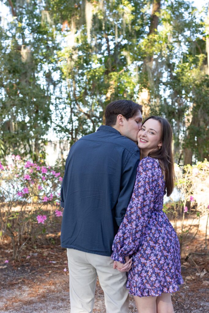 Guy kisses girl's cheek for their engagement photos at Kraft Azalea in Orlando, Florida