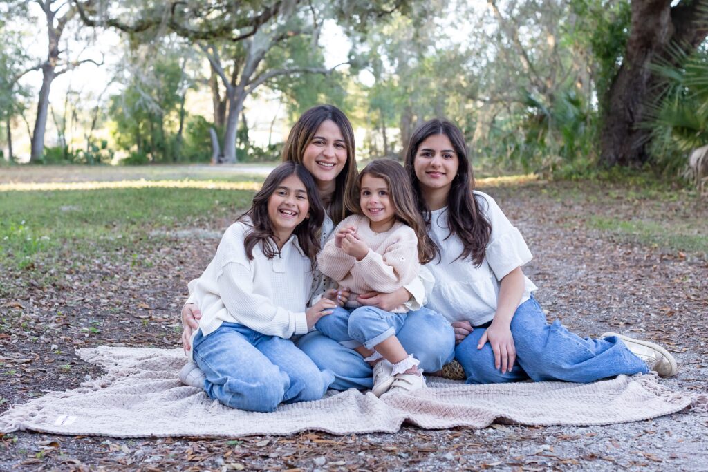 Mom sits with daughters on blanket for their family photos at Greenwood Lakes Park in Lake Mary, Florida with Orlando Family Photgrapher Amy Britton Photography