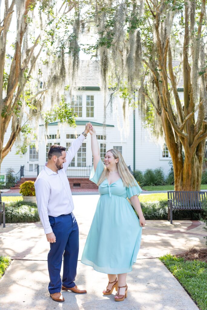 Guy twirls girl for their engagement photos at Leu Gardens in Orlando Florida