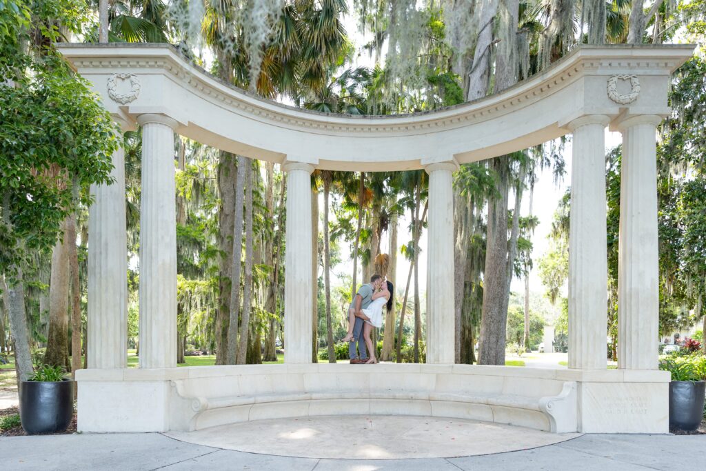 Guy dips girl and kisses her in front of columns at Kraft Azalea Park in Winter Park, Orlando, Florida