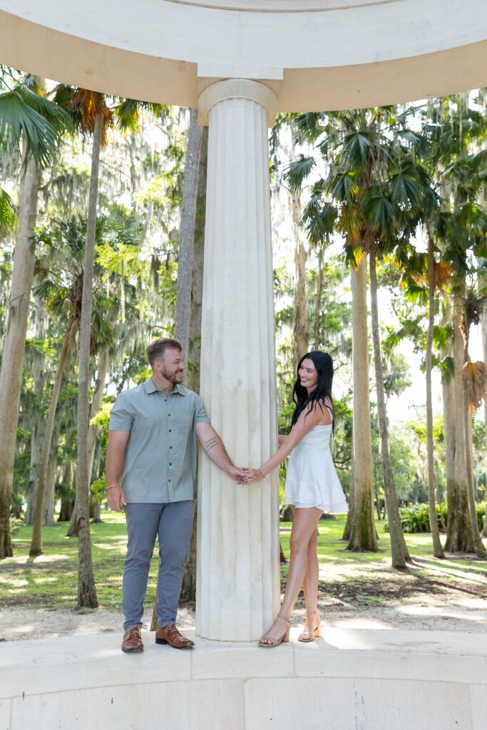 Couple holds hands in front of columns at Kraft Azalea Park in Winter Park, Orlando, Florida