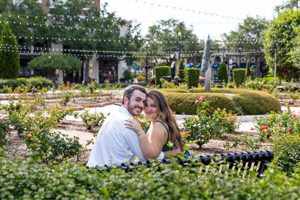 Couple poses on bench in the Rose Garden in Central Park Winter Park, Florida