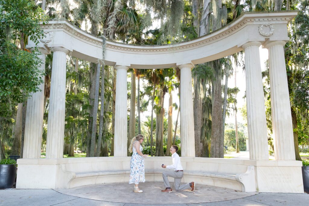 Guy proposes to girl in front of Columns at Kraft Azalea Garden for their Winter Park Proposal