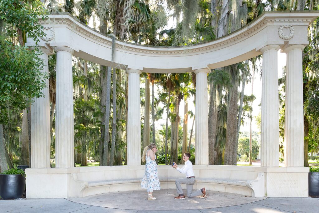 Guy proposes to girl in front of Columns at Kraft Azalea Garden for their Winter Park Proposal