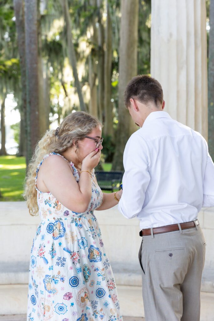 Guy proposes to girl in front of Columns at Kraft Azalea Garden for their Winter Park Proposal