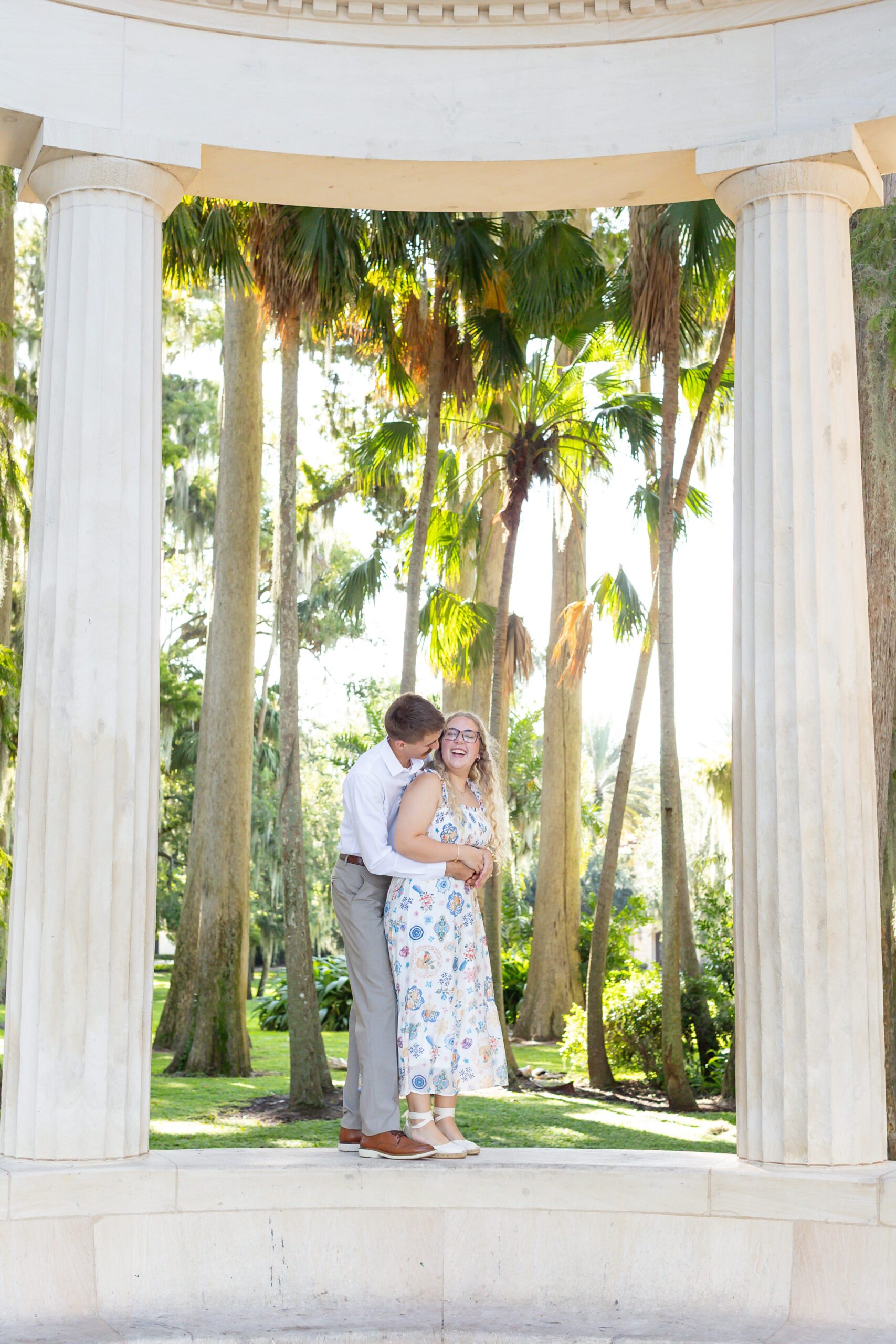 Couple hugs on top of Columns at Kraft Azalea Garden for their Winter Park Proposal