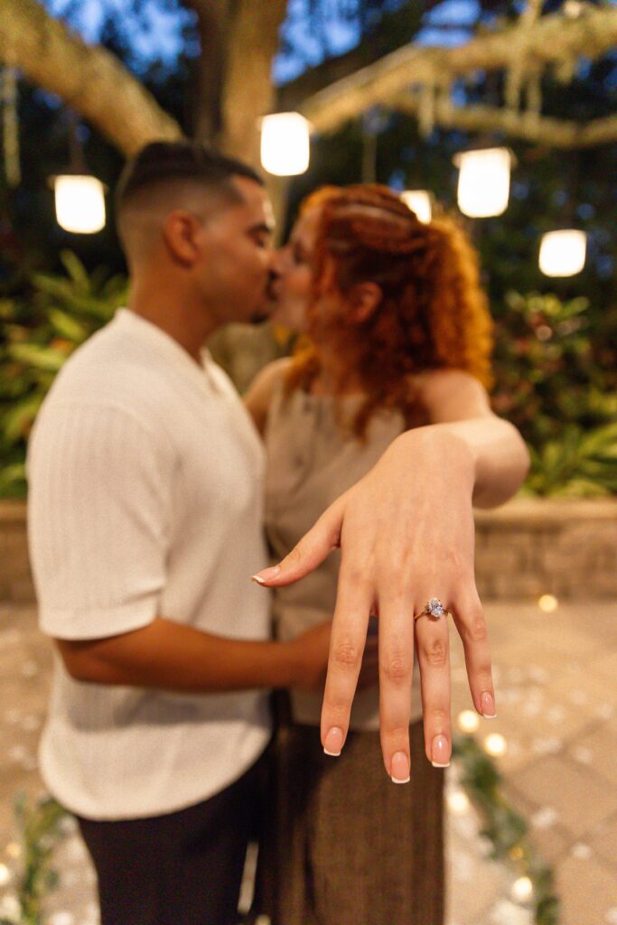 Couple kisses under tree with lanterns after their proposal at the Hyatt Regency Grand Cypress Resort Orlando Oak Terrace