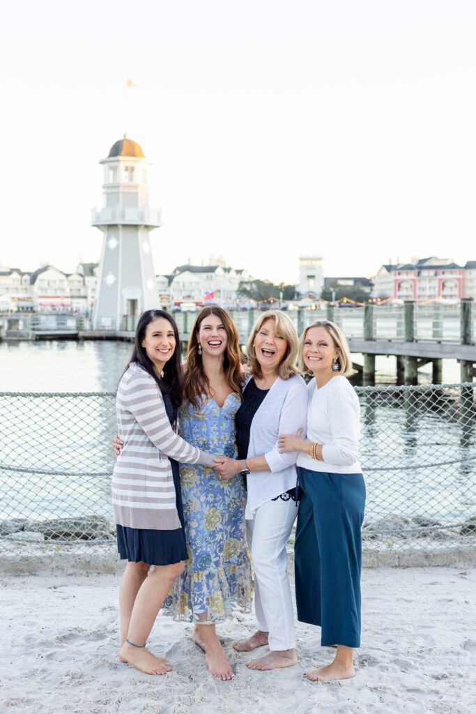 Family holds hands and laughs at Beach Club at Disney Resort in Orlando Florida