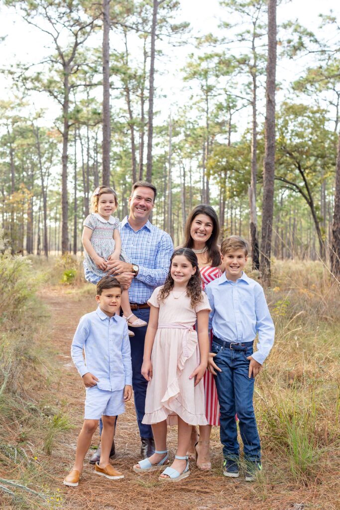 Family smiles in field at Wekiva Springs State Park for their family photos